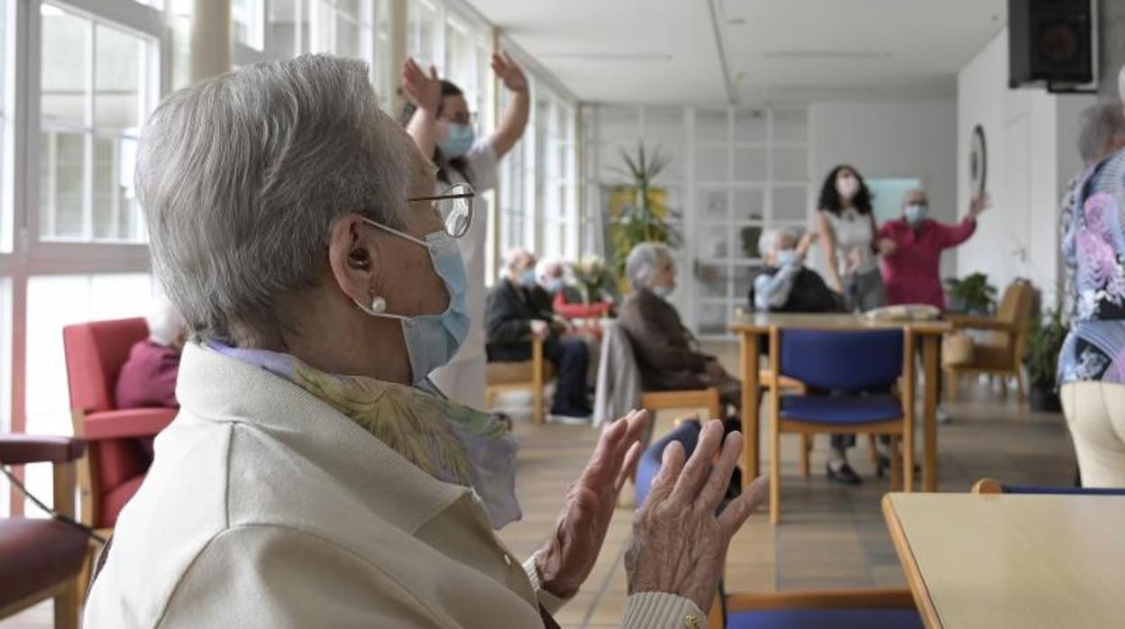 Un grupo de mayores hace ejercicios en una residencia manteniendo el protocolo Covid