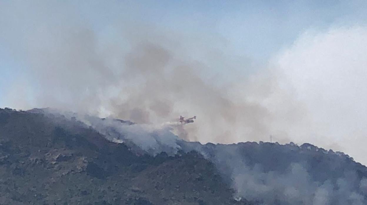 Un avión descarga sobre la montaña ardiendo