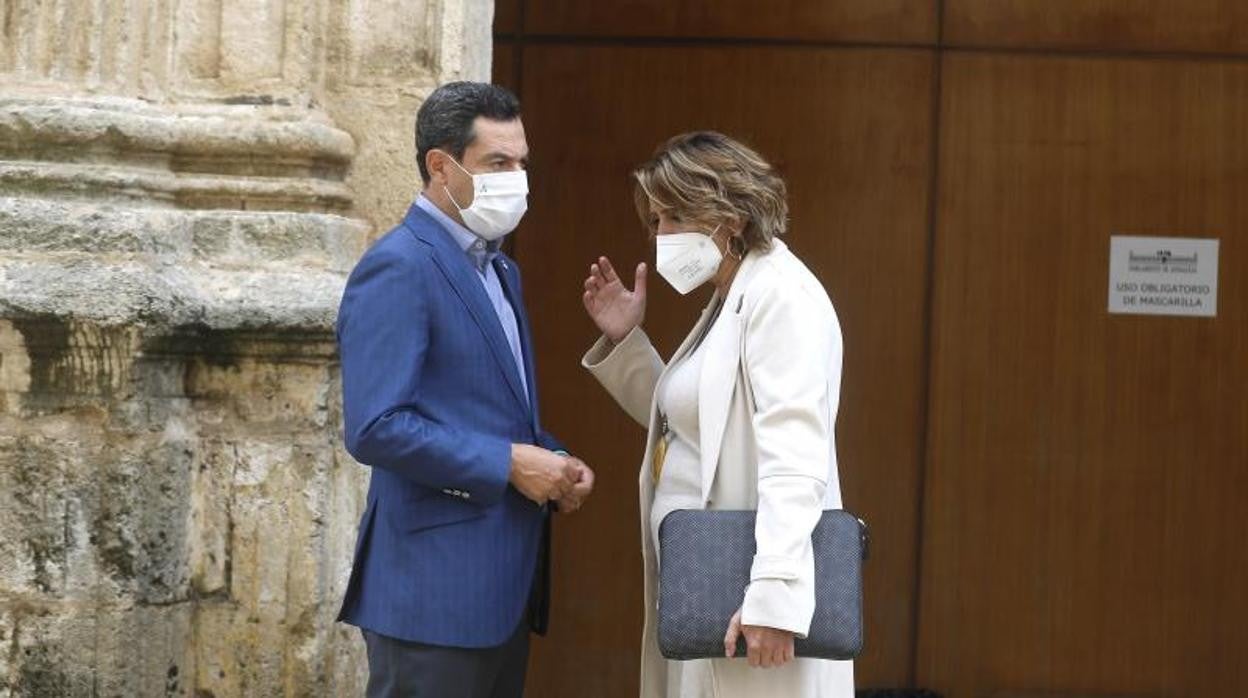 El presidente de la Junta, Juanma Moreno, dialoga con Susana Díaz en una de las puertas del salón de plenos del Parlamento andaluz este miércoles