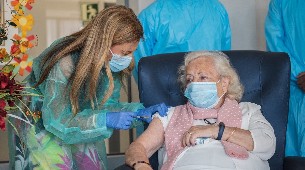 Una enfermera administra la tercera dosis a una residente de un centro de mayores de Granada