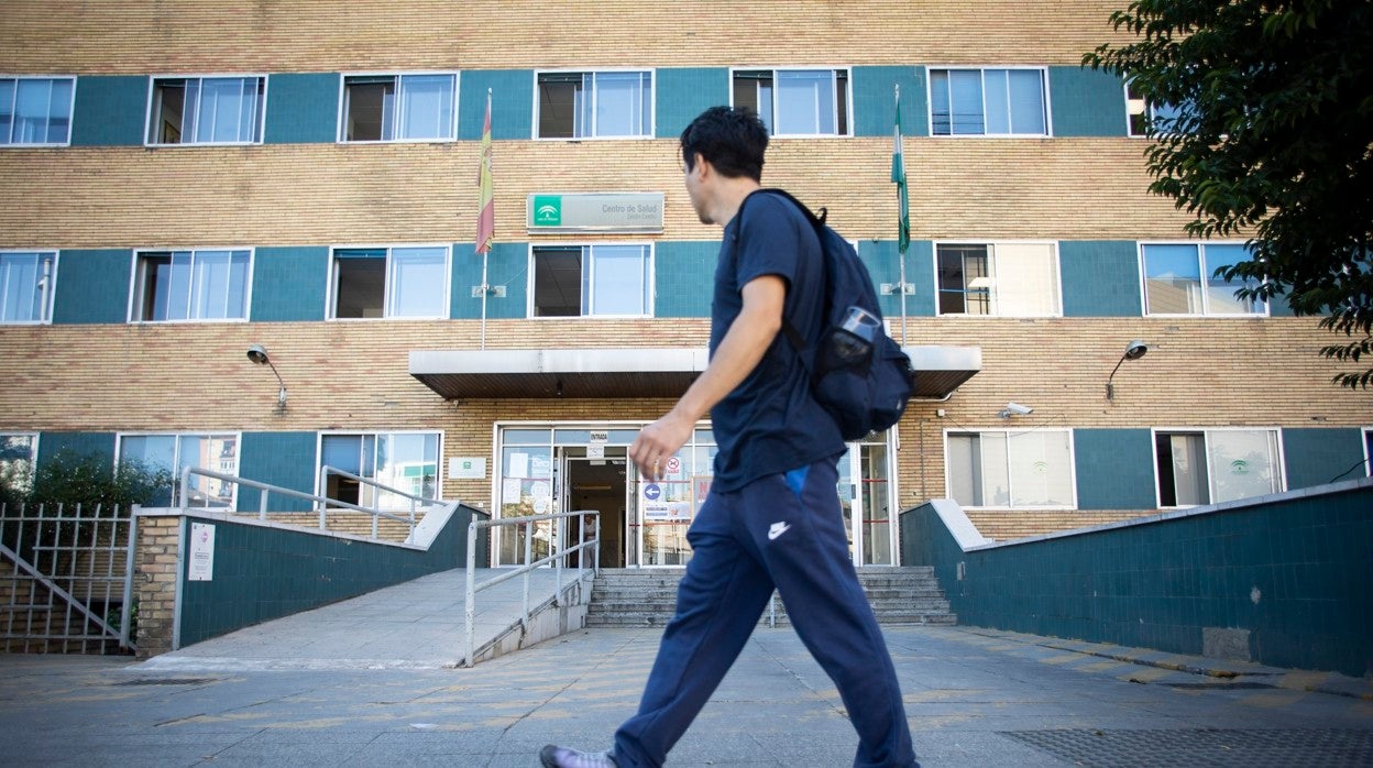 Un joven sanitario camina frente a un ambulatorio cerca de la Facultad de Medicina en Granada
