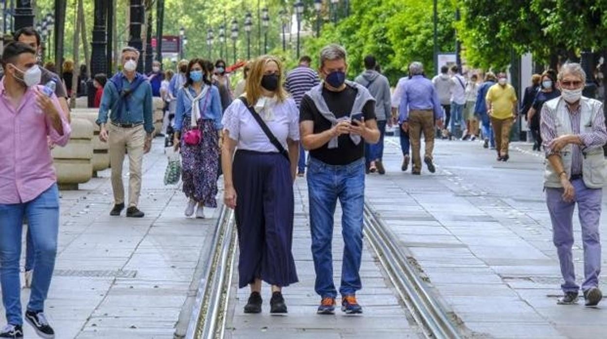 Varias personas pasean por la Avenidad de la Constitución de Sevilla
