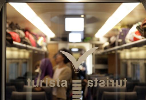 Una mujer coloca su equipaje en un vagón del AVE