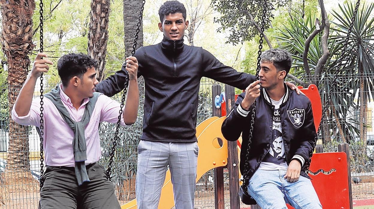 Tres menores extutelados posan en un parque de Sevilla