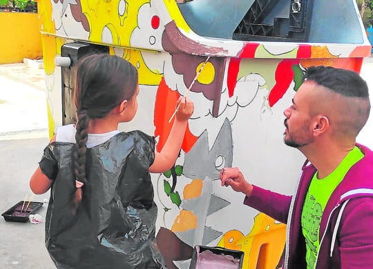 Una niña pinta un contenedor en la actividad promovida por Sadeco