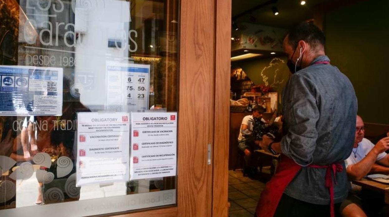 Carteles de indicaciones de obligatoriedad de presentar certificados en una marisquería de Santiago de Compostela