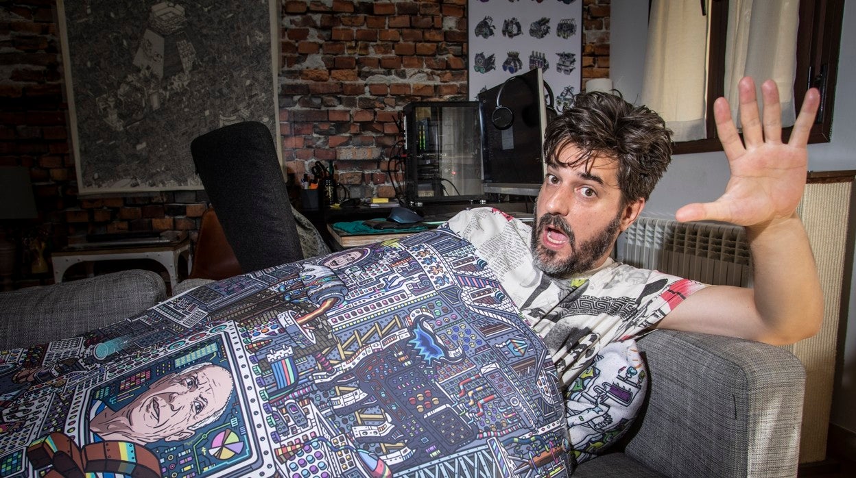 Javier Arrés posa para ABC tumbado en el sofá de su casa y cubierto por una de sus obras