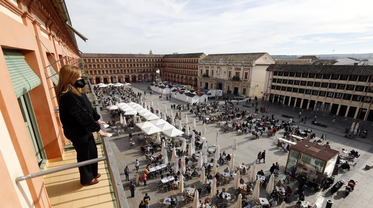 Una vecina contempla desde su balcón el estado actual de la la plaza de la Corredera de Córdoba