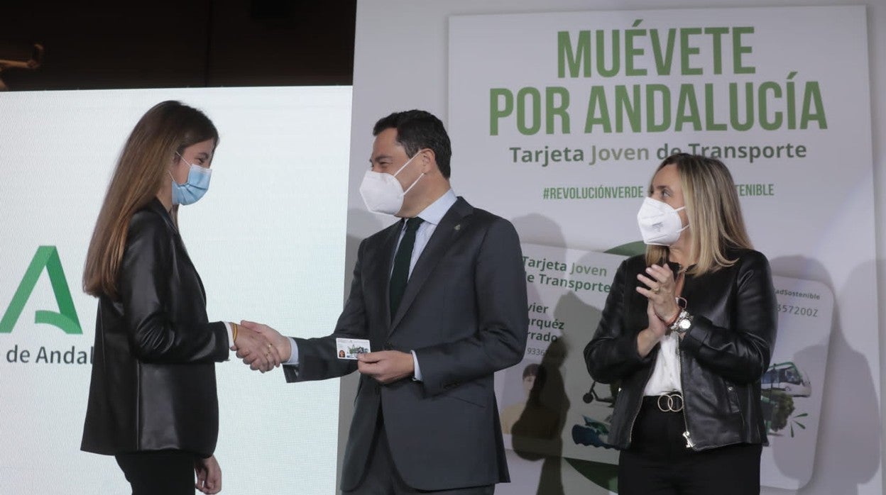 Moreno entrega a una joven una de las nuevas tarjetas en compañía de la consejera de Fomento, Marifrán Carazo, en la estación de metro San Bernardo en Sevilla