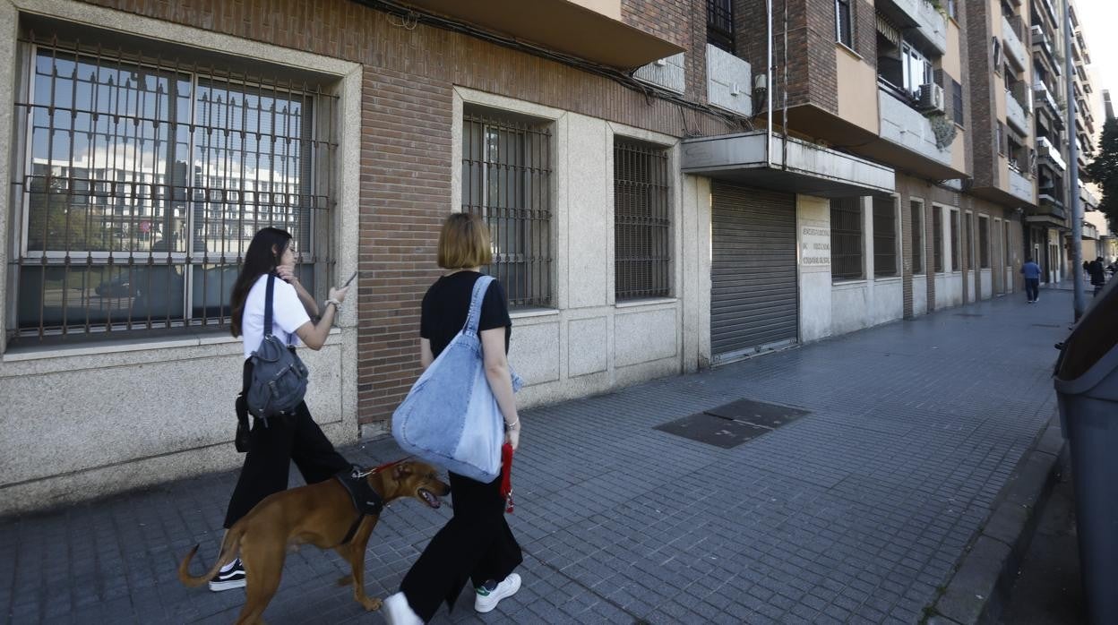 Dos viandantes pasan ayer delante del local bajo que ocupará la nueva oficina policial del DNI en Córdoba