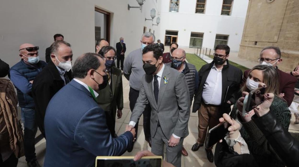 El presidente de la Junta, Juanma Moreno, saluda a los ganaderos de Granada en un pasillo del Parlamento