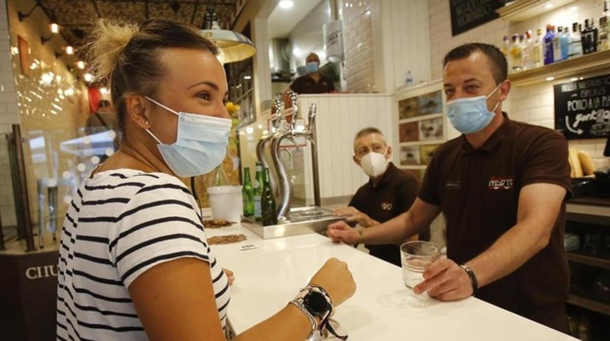 Clientes con mascarilla en un bar