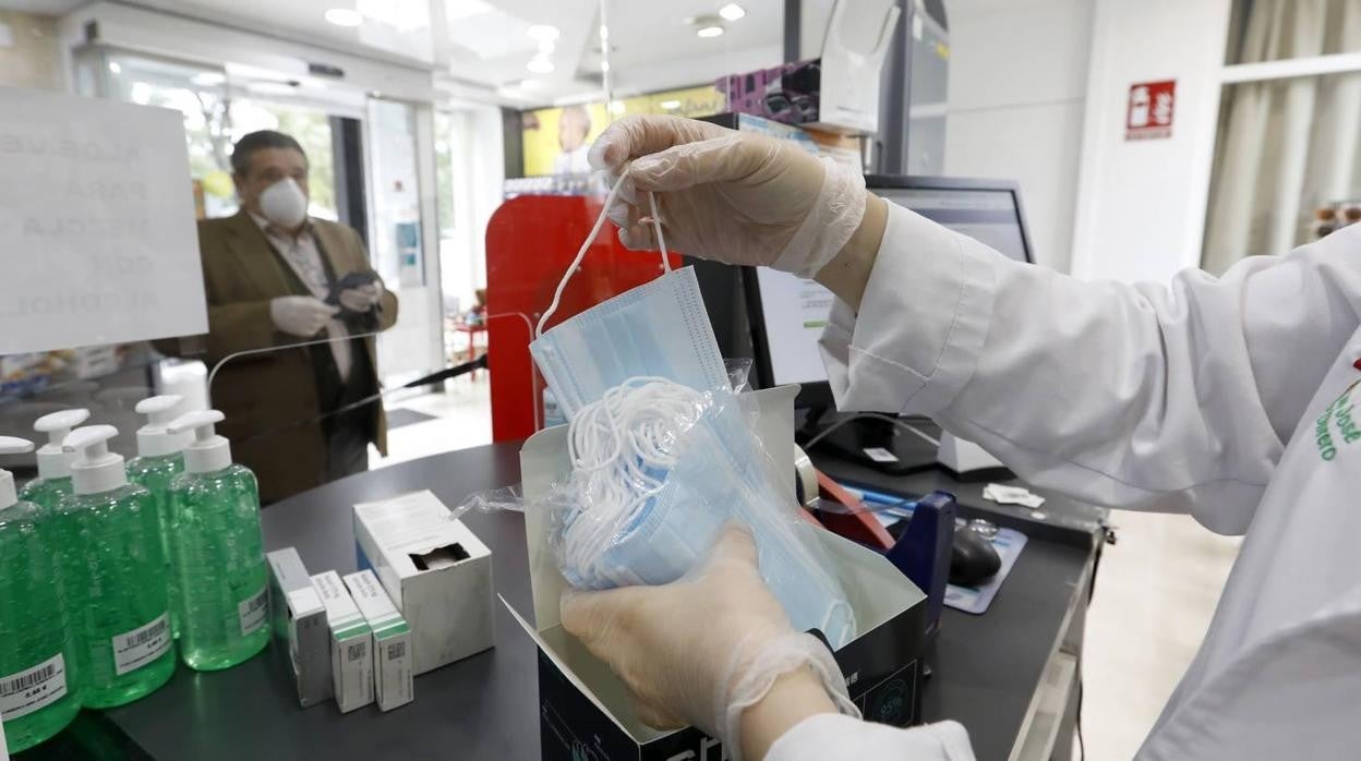 Una farmacéutica vendiendo cubrebocas