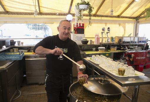Carlos Muñoz sirviendo caracoles en su puesto de la avenida de Granada