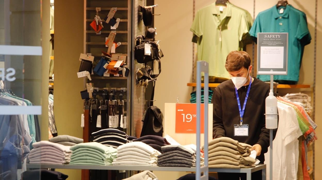 Un dependiente en el interior de un comercio de Córdoba con mascarilla