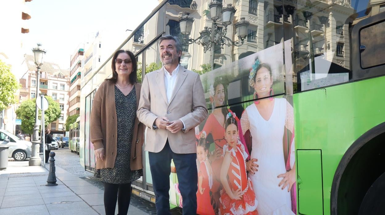 Ana Tamayo, gerente de Aucorsa, y Miguel Ángel Torrico posan ante un autobús con imágenes de Feria