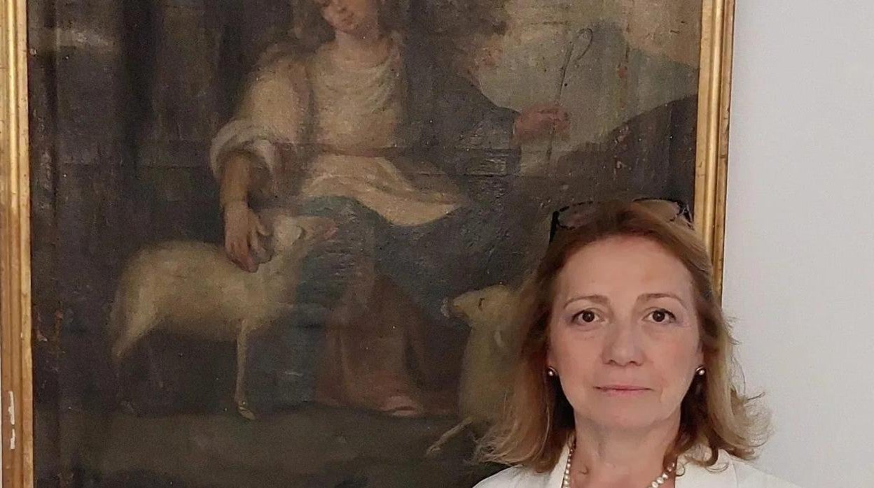 Inmaculada Luque, ante un cuadro en que se representa a la Divina Pastora