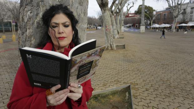 Eva Díaz Pérez lee un ejemplar de su libro en la Alameda