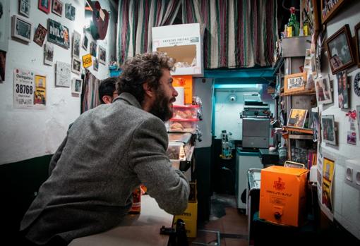 Juanito busca la foto de Ramón en la pared del bar