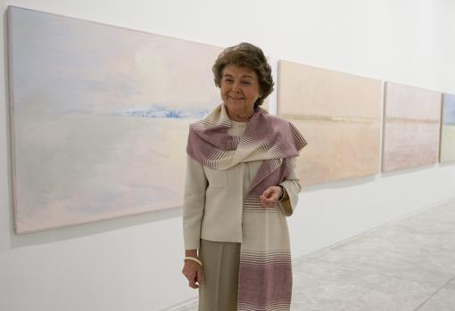 La artista sevillana Carmen Laffón junto a sus cuadros en una exposición