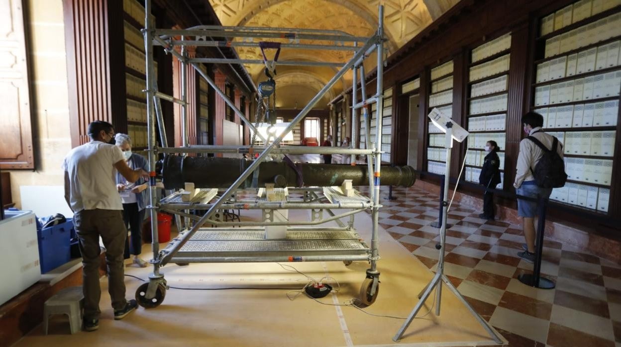 Público observando el proceso de restauración del cañón en las galerías superiores del Archivo de Indias