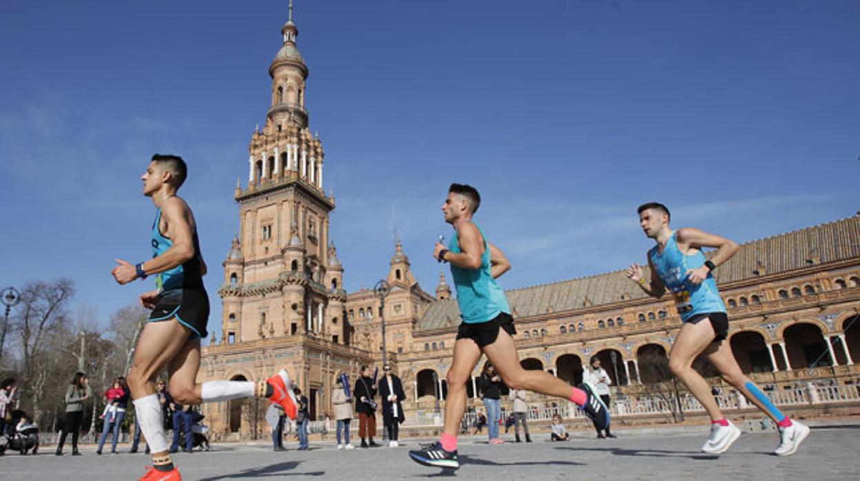 Varios participantes pasan por la Plaza de España durante el Zurich Maratón Sevilla de 2019