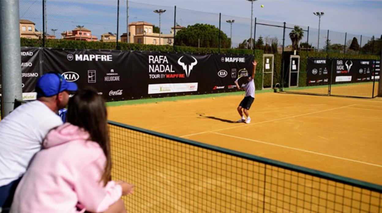 Un tenista inicia un saque en las pistas de albero del Club Río Grande