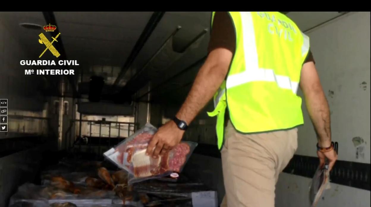 Un guardia civil con algunos de los productos ibéricos intervenidos
