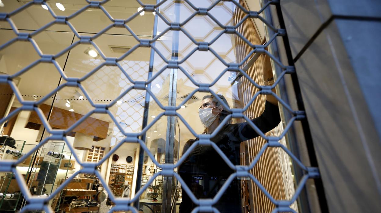 Un comerciante baja la persiana de su establecimiento en Córdoba