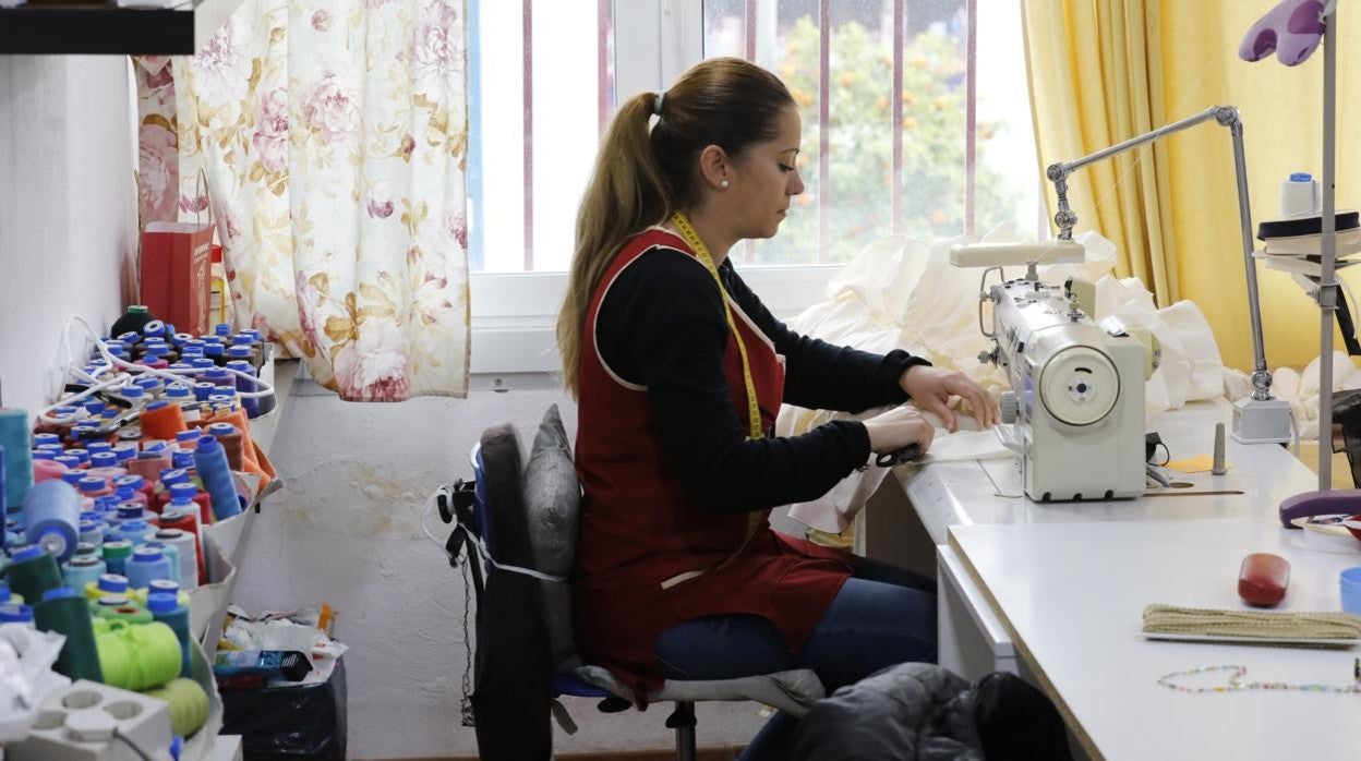 Una modista trabaja en un taller de moda flamenca