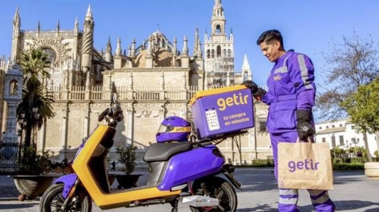 Un repartidor de la cadena de entregas ultra rápidas Getir, enseña que acaba de aterrizar en Sevilla