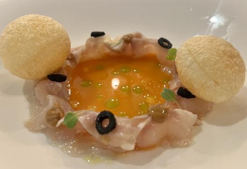 Ceviche de lubina marinado en AOVE con aceituas negras, crema de cacahuete y leche de tigre de pimiento rojo, ceborra, limón y un toque de cilantro