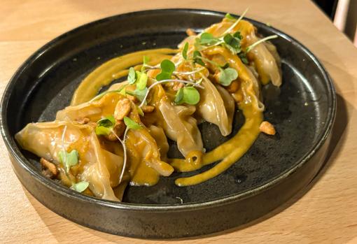 Gyozas de langostinos con salsa de coco, curry y cacahuete.