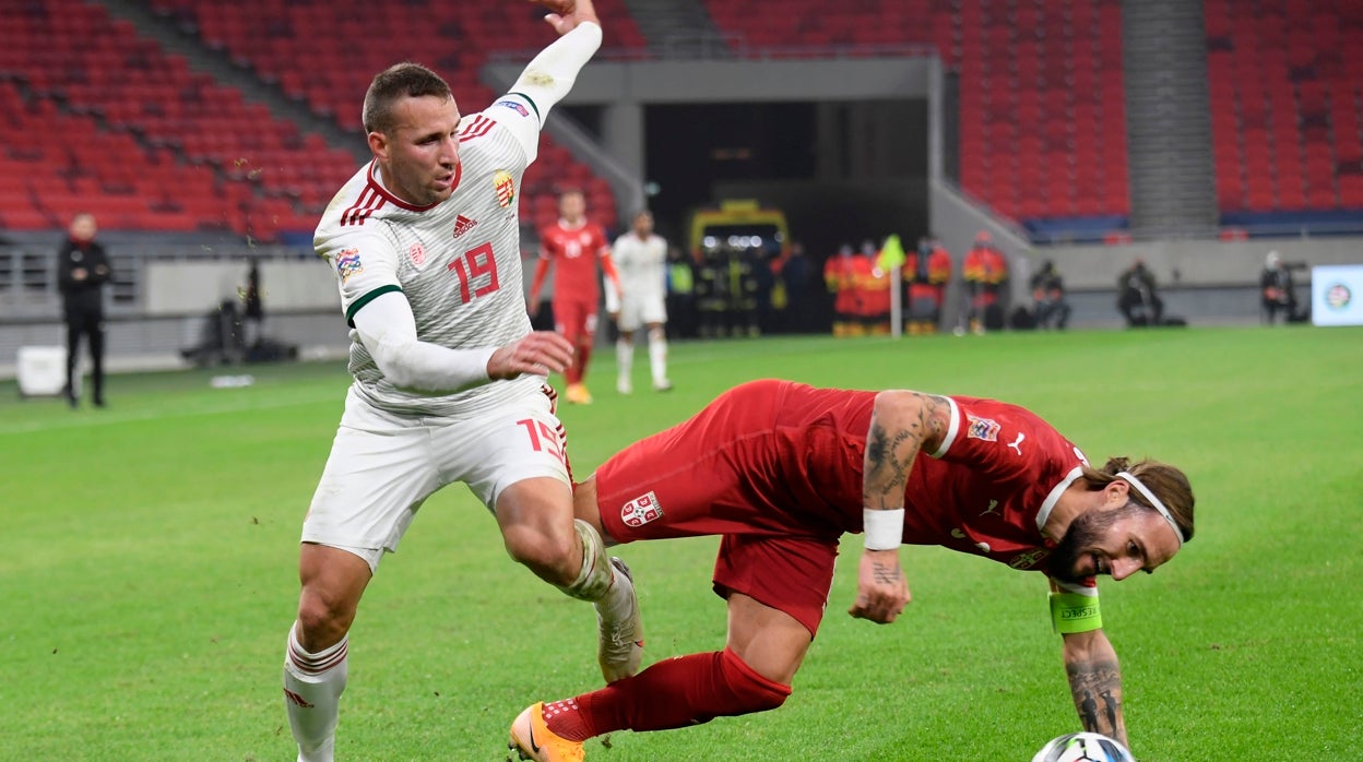 Gudelj cae al suelo durante un partido con Serbia
