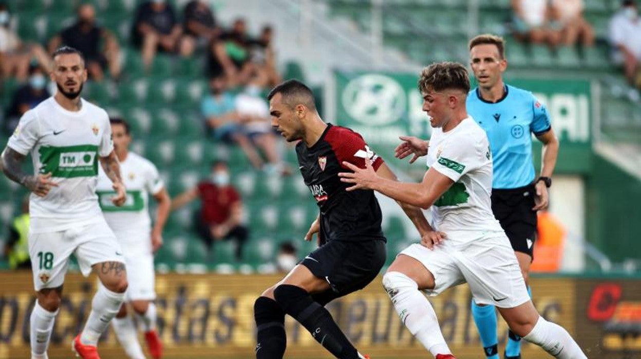 Joan Jordán protege el esférico ante Raúl Guti bajo la atenta mirada de Pizarro Gómez
