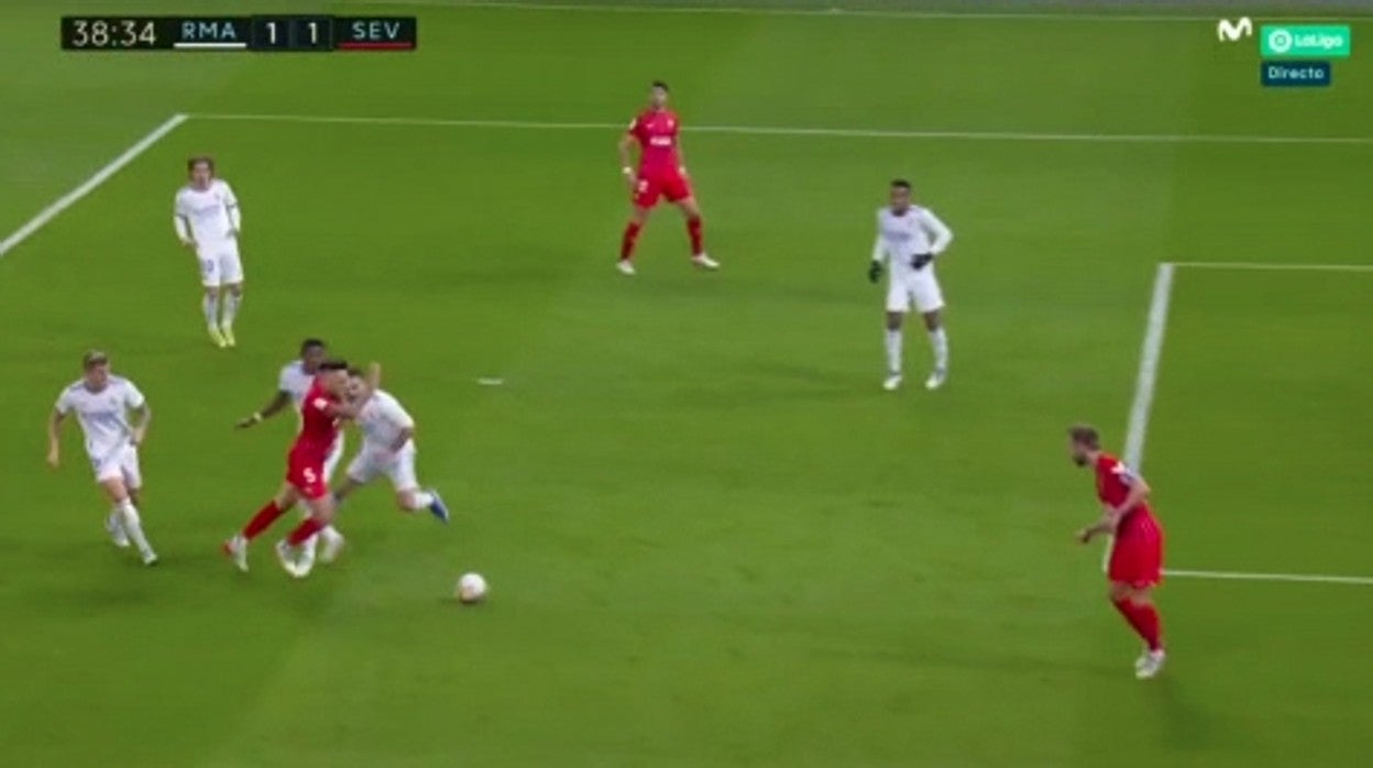 El pie de Alaba toca en zancadilla al de Ocampos en el área madridista durante el Real Madrid - Sevilla FC