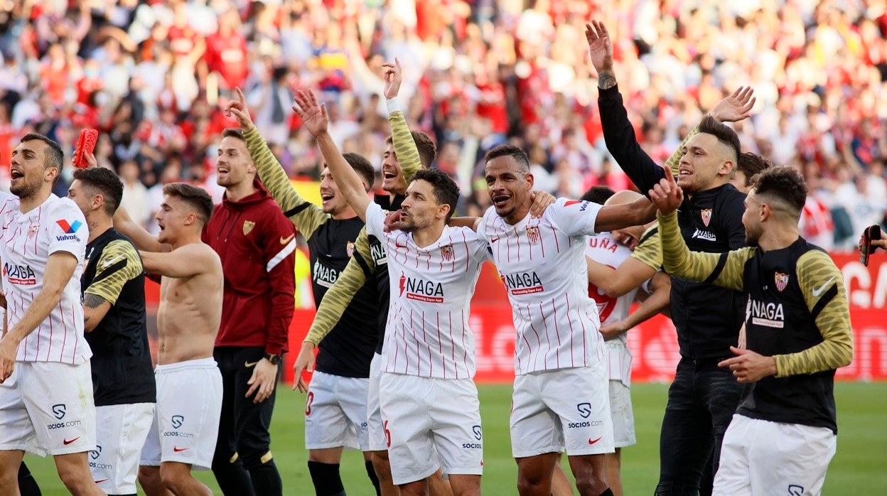 Los jugadores del Sevilla celebran con la afición el triunfo en el derbi