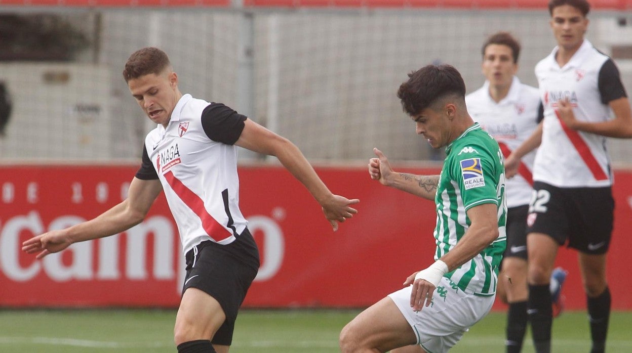 El bético Juan Cruz presiona a Nacho Quintana, que protege un balón de espaldas