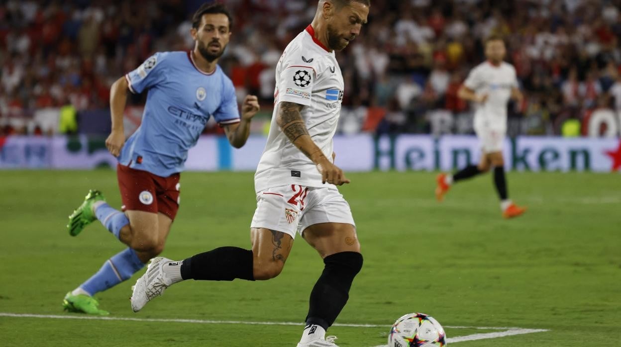 Papu Gómez avanza ante Bernardo Silva durante el Sevilla - Manchester City