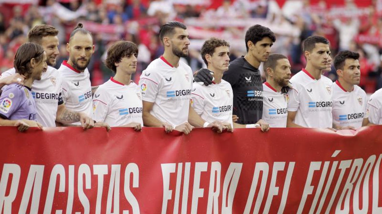 Los jugadores del Sevilla y del Real Madrid portan una pancarta contra el racismo antes del partido