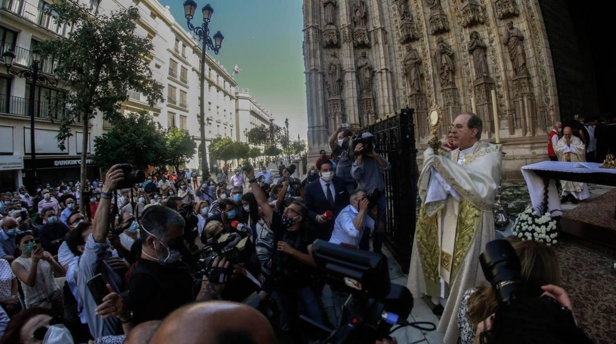 El arzobispo de Sevilla, Juan José Asenjo, bendice al pueblo en la puerta de la Asunción en el Corpus 2020