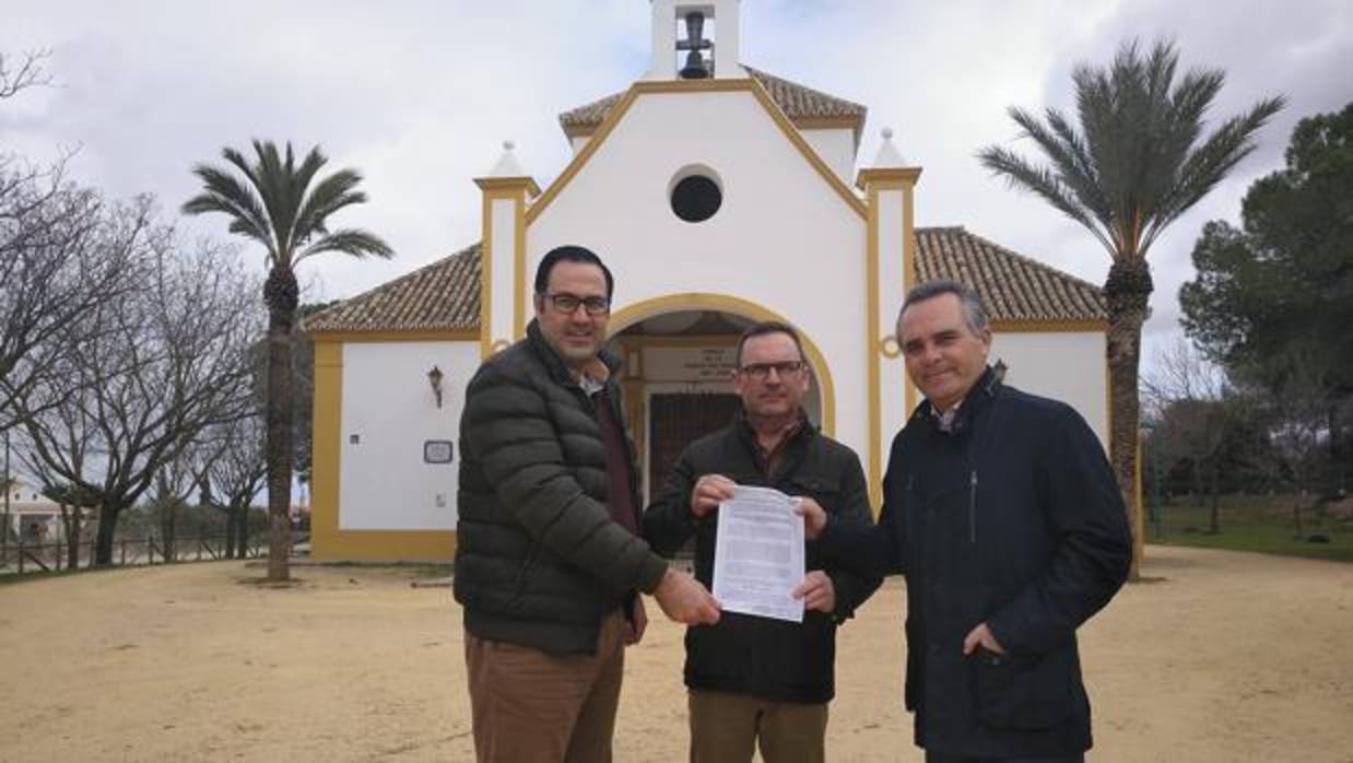 Representantes locales del PP y Juan Bueno, a la derecha, con la resolución de la comisión ante la ermita de la patrona