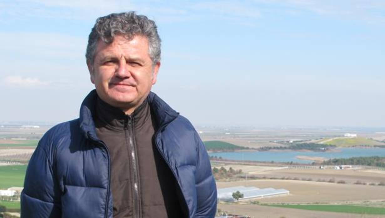 José Antonio García con la balsa de Melendo, cola del Canal de los Presos, al fondo