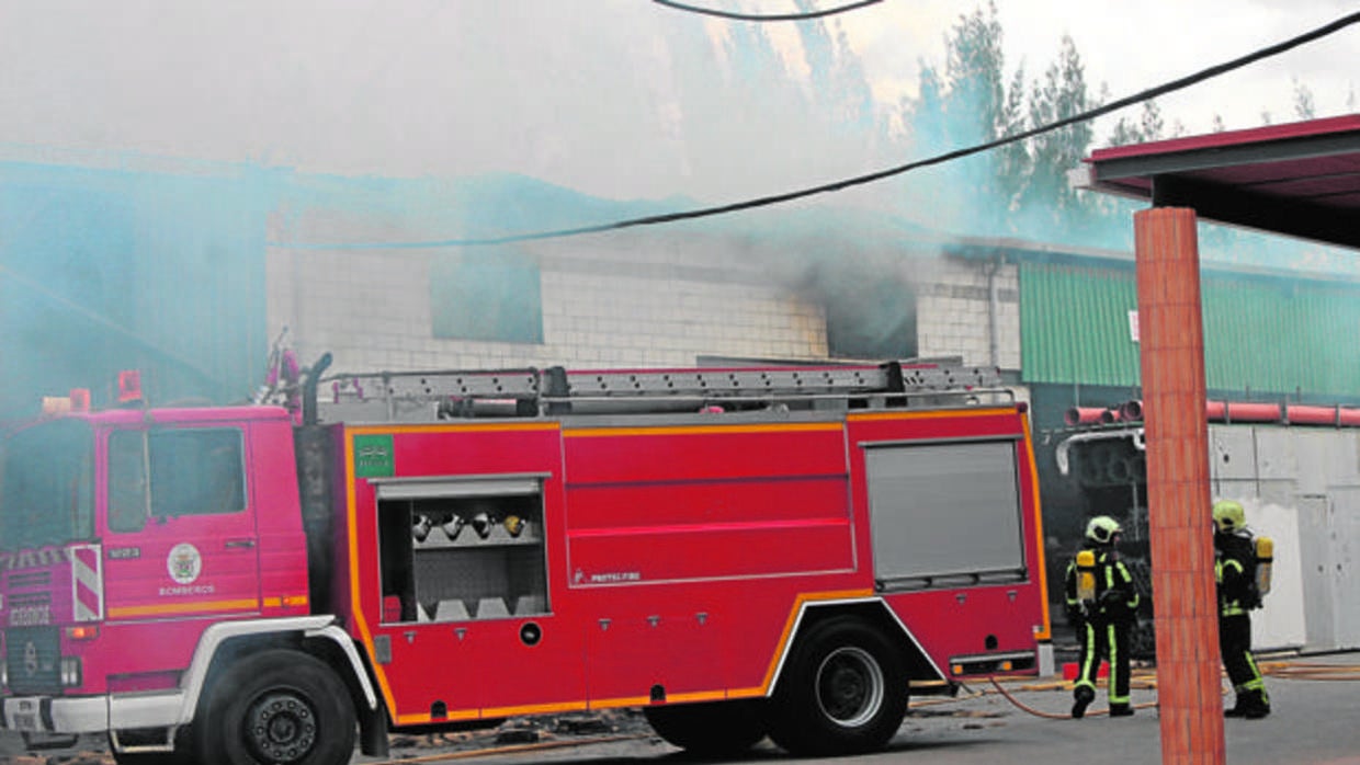 Efectivos de los Bomberos ante la ferretería calcinada