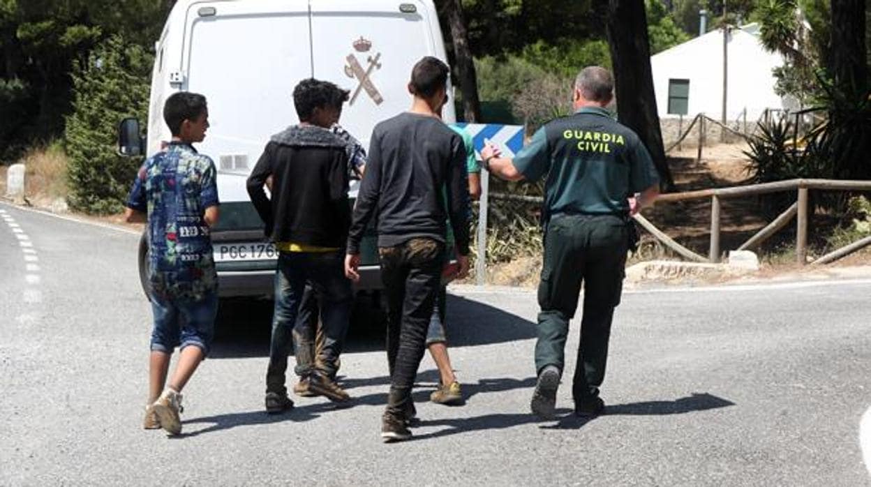 Un guardia civil acompaña a un grupo de menores extranjeros que se había escapado en Barbate