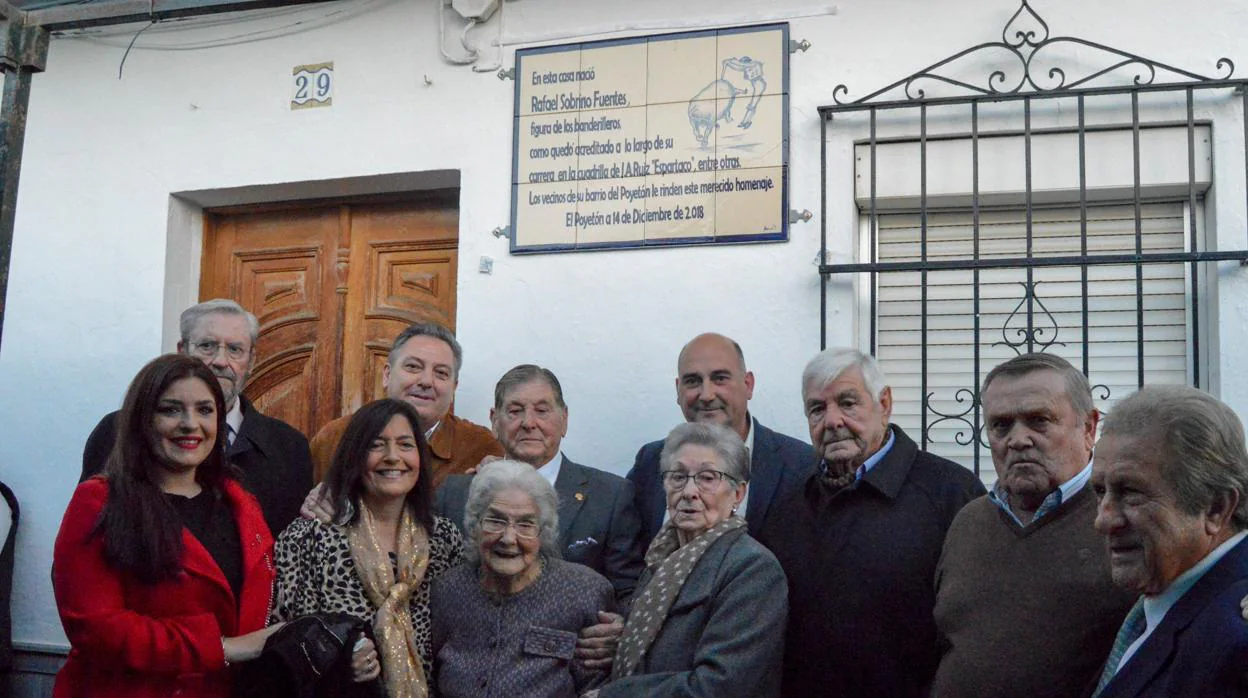 Rafael Sobrino posa, acompañado por varios vecinos, junto al azulejo descubierto en su honor