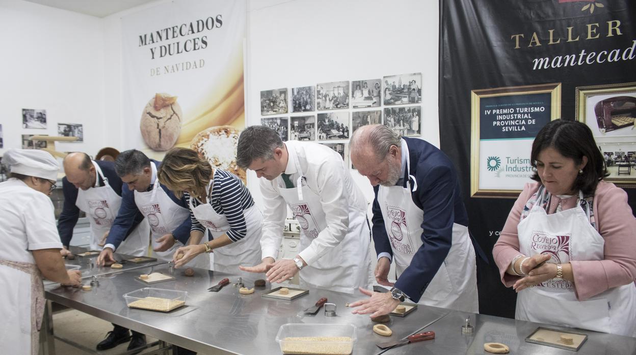 Susana Díaz y Rodríguez Villalobos, entre otros, preparan un mantecado de forma artesanal, durante su visita a Estepa