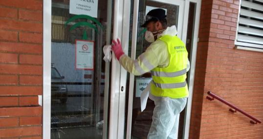 Un operario desinfecta la puerta de entrada al Centro de Salud de Marchena