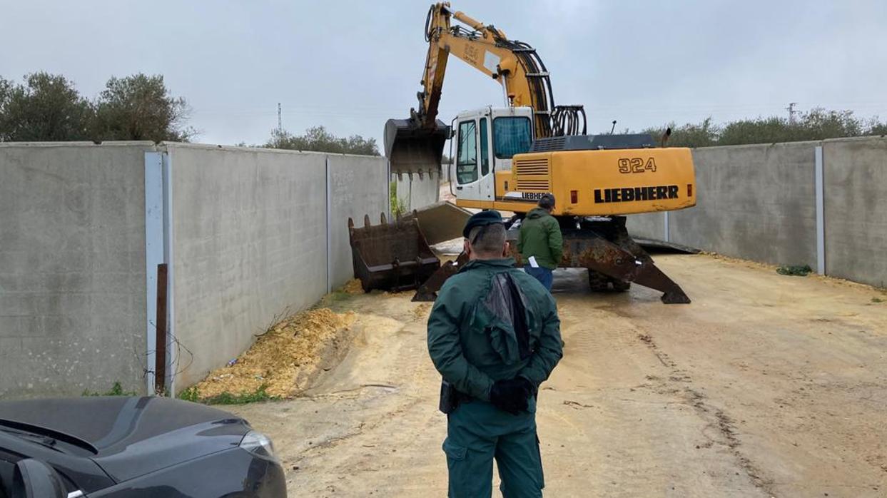 Un agente de la Guardia Civil vigila el derribo de los muros de las parcelas