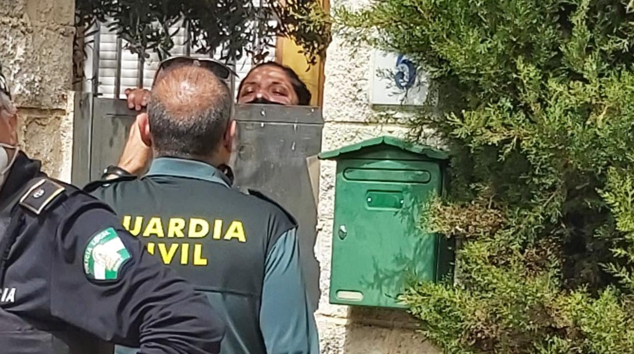 Un agente de la Guardia Civil dialoga con una persona de la primera okupación del chalé de Gines